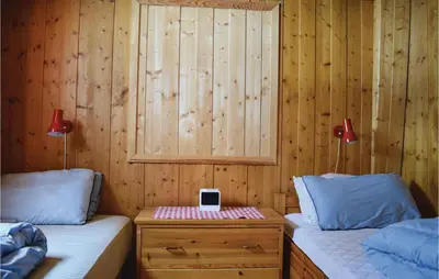 a bedroom with two beds and a table with a ipod on it at 5 Bedroom Stunning Home In Noresund in Noresund