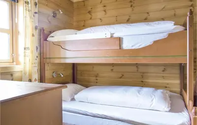 a room with three bunk beds in a cabin at Four-Bedroom Holiday Home In Roldal in Røldal