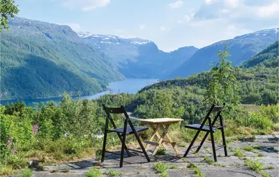 two chairs and a table with a view of a lake at Four-Bedroom Holiday Home In Roldal in Røldal
