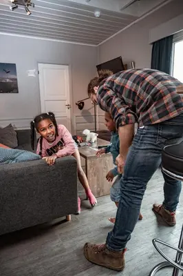 a man standing in a living room with a little girl at Hemsedal Cafe Skiers Lodge in Hemsedal