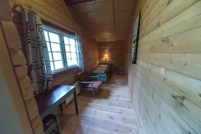 a hallway in a log cabin with a bench and a window at Dombås Hostel in Dombås