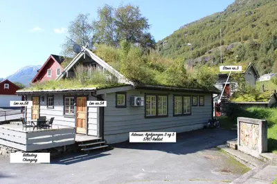 a house with a grass roof with signs on it at Røldalstunet Overnatting in Røldal