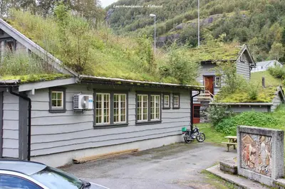 a house with a grass roof with a car parked outside at Røldalstunet Overnatting in Røldal