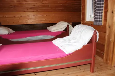 two bunk beds in a room with wooden walls at Røldalstunet Overnatting in Røldal