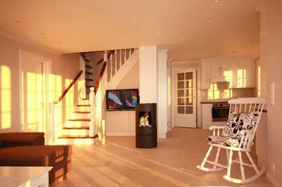 a living room with a fireplace and a staircase at Nordica Resort Florø in Florø
