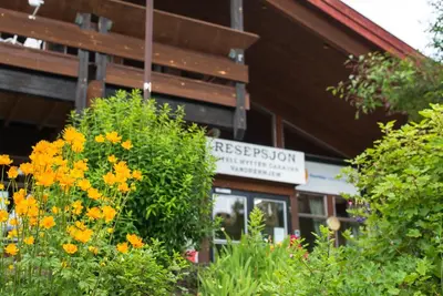 a building with flowers in front of a building at Hytter Dombås in Dombås