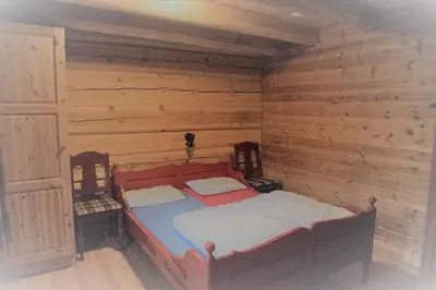 a bed in a room with wooden walls at Hytter Dombås in Dombås