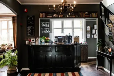 a coffee shop with a bar in a room at Fjærland Fjordstove Hotell - Huseby Hotelldrift AS in Fjarland