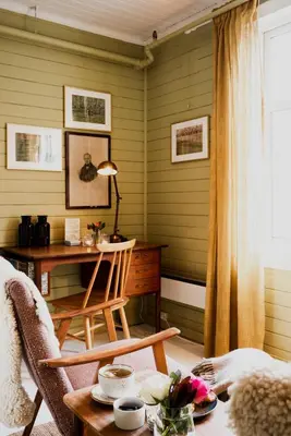 a room with a desk and a table with a chair at Fjærland Fjordstove Hotell - Huseby Hotelldrift AS in Fjarland