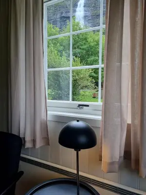 a black chair sitting in front of a window at Vassbakken Kro og Camping in Skjolden
