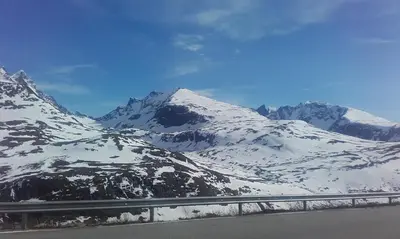 a mountain range with snow on the side of a road at Vassbakken Kro og Camping in Skjolden