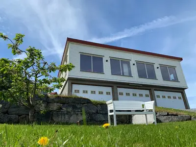 a white bench sitting in front of a house at Olden Fjord Apartments in Olden