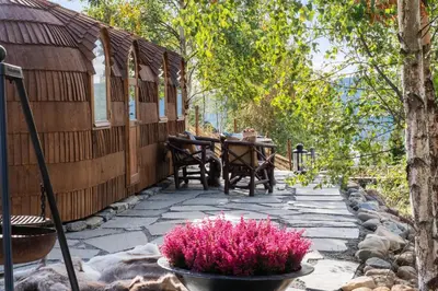 a patio with a table and pink flowers at Konglehytta 1 - 30 min fra OSL - Badstu - Utsikt - Romantikk in Strandlykkja