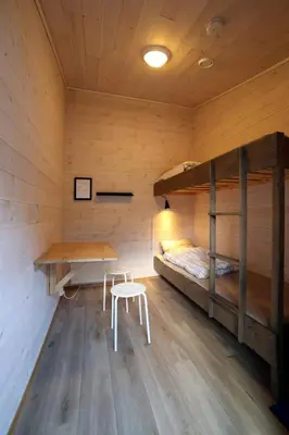 a room with two bunk beds and a table and stool at Trolltunga Camping in Odda