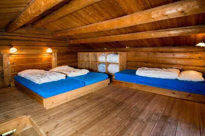 two beds in a log cabin with wooden floors at Kvitåvatn Fjellstue in Gaustablikk