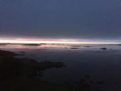 a large body of water with the sunset in the background at Finnøya with 180* Atlantic veiw in Finnøy