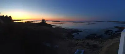 a sunset over a body of water with a tree at Finnøya with 180* Atlantic veiw in Finnøy