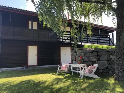 two chairs and a table in front of a house at Drolsum Gård in Vikersund