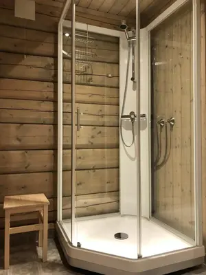 a shower in a bathroom with wooden walls at Drolsum Gård in Vikersund