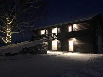 a log cabin in the snow at night at Drolsum Gård in Vikersund