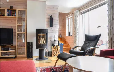 a living room with a fireplace and a table and chairs at Fjellstua C3, Leil 202 in Sjusjøen