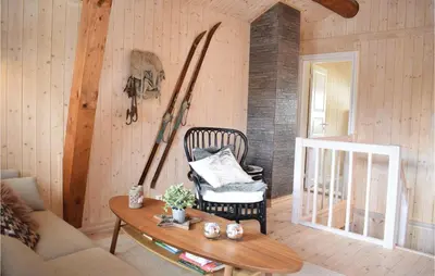 a room with a chair and skis on the wall at Three-Bedroom Holiday Home In Hovet in Hovet