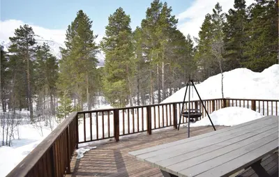 a wooden deck with a swing in the snow at Three-Bedroom Holiday Home In Hovet in Hovet