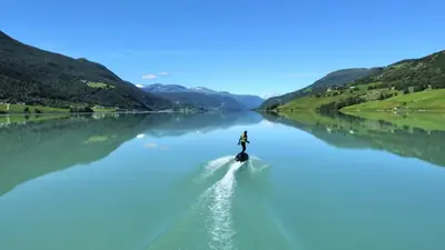 a person is riding a boat on a river at Vågåvatnet Feriesenter in Vågåmo