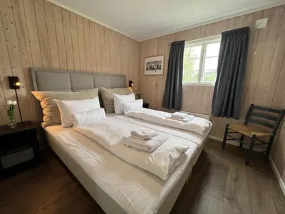 a bedroom with a large bed with towels on it at Vågåvatnet Feriesenter in Vågåmo