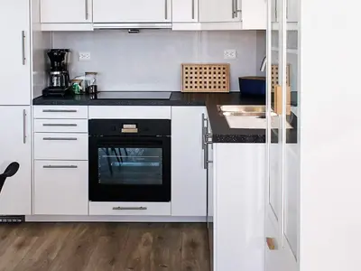 a kitchen with white cabinets and a black oven at 10 person holiday home in Brattvåg in Brattvåg