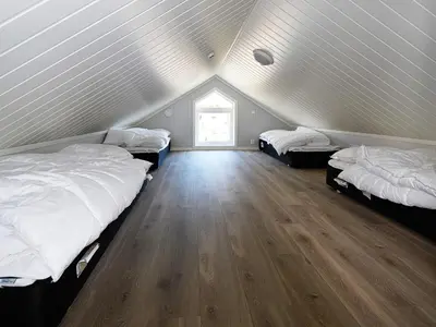 a attic room with three beds and a window at 10 person holiday home in Brattvåg in Brattvåg