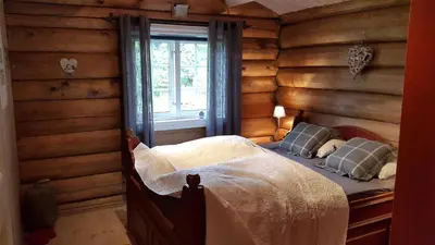 a bedroom with a bed in a room with wooden walls at Koselig familiehytte sentralt på Skeikampen til leie in Svingvoll
