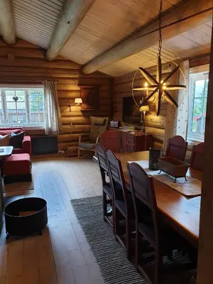 a dining room with a large wooden table and chairs at Koselig familiehytte sentralt på Skeikampen til leie in Svingvoll