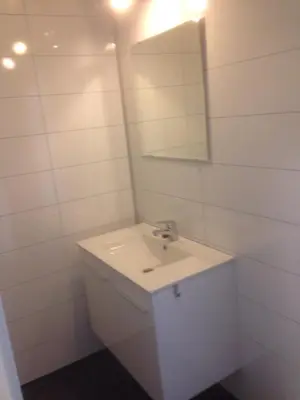 a white bathroom with a sink and a mirror at Malenes Ferieleiligheter in Rauland