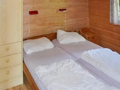 two beds in a room with wooden walls at 8 person holiday home in olden in Olden