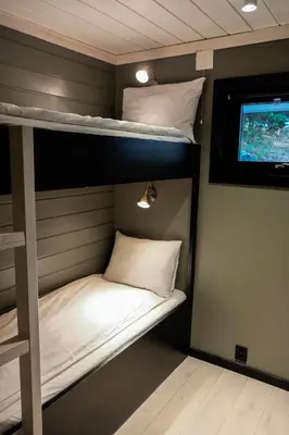 two bunk beds in a room with a tv at Hemsetunet Apartments in Hemsedal