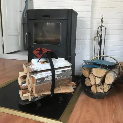 a stack of logs next to a fireplace at Charming Lakeside House with sauna in Lillehammer