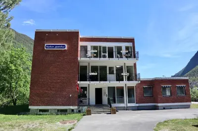 a red brick building with a sign on it at Rjukan Gjestehus in Rjukan