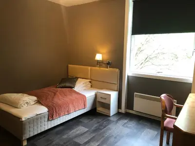 a small bedroom with a bed and a window at Rjukan Gjestehus in Rjukan