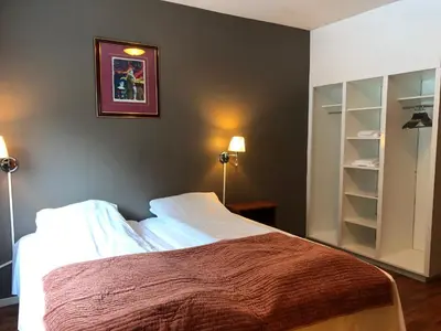 a bedroom with a bed and a picture on the wall at Rjukan Gjestehus in Rjukan