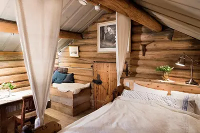 a bedroom with wooden walls and a bed in a room at Nutheim Gjestgiveri in Flatdal