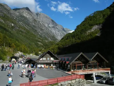 a group of people walking around a building in the mountains at Briksdalsbre Fjellstove in Briksdalsbre