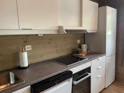 a kitchen with white cabinets and a sink at Briksdalsbre Fjellstove in Briksdalsbre