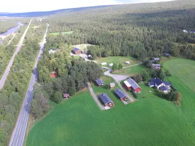 an aerial view of a large green field with houses at Roste Hyttetun og Camping in Os