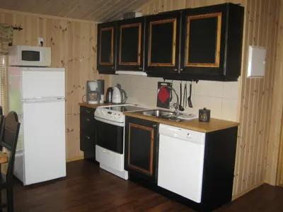 a kitchen with a white refrigerator and a sink at Roste Hyttetun og Camping in Os