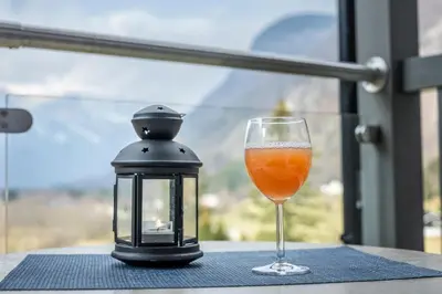 a lantern and a glass of orange juice on a table at Skaimsberg Holiday Apartments in Aurland