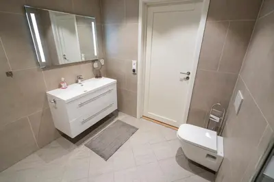 a bathroom with a sink and a toilet and a mirror at Skaimsberg Holiday Apartments in Aurland