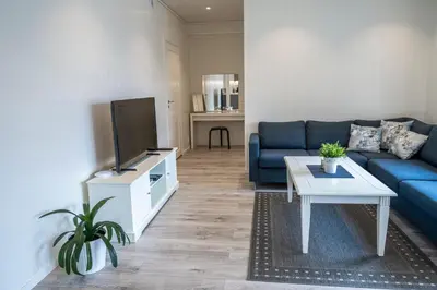 a living room with a blue couch and a tv at Skaimsberg Holiday Apartments in Aurland
