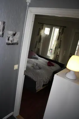a small bedroom with a bed and a mirror at Huset på hauen in Volda