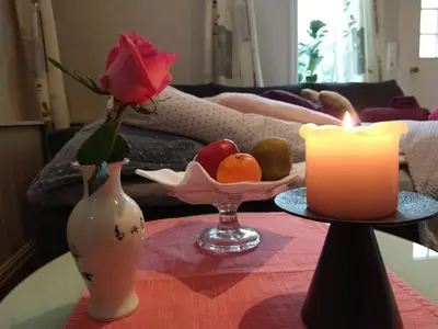 a table with a candle and a vase with a rose at Huset på hauen in Volda